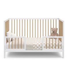 a white crib with a teddy bear in it