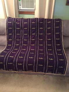 a purple blanket sitting on top of a couch