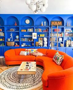 a living room with blue shelves and orange couches