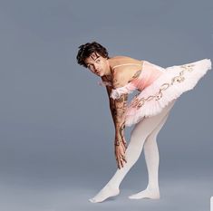 a ballerina in pink and white is posing for the camera