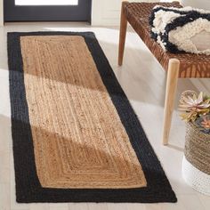 an area rug with black and tan stripes on the floor in front of a chair