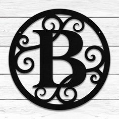 the letter b is made out of metal and sits on top of a wooden wall