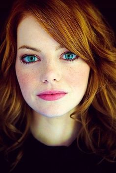 a close up of a person with long hair and blue eyes looking at the camera