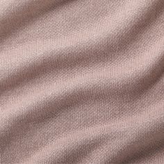 a close up view of a pink fabric textured with thin, straight lines and folds