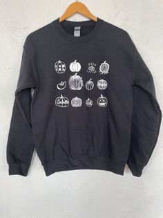 "This listing is for a unisex sweatshirt screen printed with a variety of hand drawn pumpkins. Perfect for halloween! It is shown here printed with white ink on a black sweatshirt. // PROCESS: All of our items are individually hand printed by either me or my dad, which can lead to slight variations in placement. The ink is heat cured and will not fade over time. Since our items are printed to order, there is a 1-2 week processing time before shipping. If you absolutely need an item shipped quick Fall Black Sweatshirt With Screen Print, Black Screen Print Sweatshirt For Fall, Spooky Black Sweatshirt With Graphic Print, Custom Print Sweatshirt For Fall Streetwear, Fall Black Sweatshirt With Custom Print, Black Tops With Custom Print For Fall, Black Top With Custom Print For Fall, Cricut Clothing, Pumpkin Sweatshirt