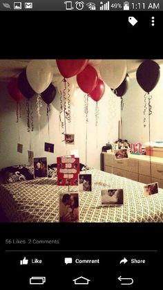 balloons are hanging from the ceiling above a bed with pictures on it and photos in front of them