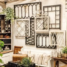 a living room filled with furniture and lots of plants on the wall next to it