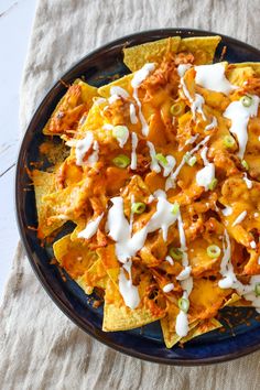 nachos with chicken, cheese and sour cream drizzled on top