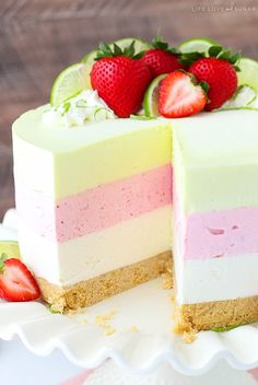 there is a cake with two layers and strawberries on the top one slice has been cut