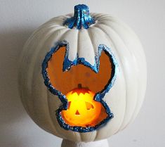 a white pumpkin with blue and orange designs on it