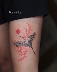 a tattoo on the leg of a woman with a bird flying over flowers and berries