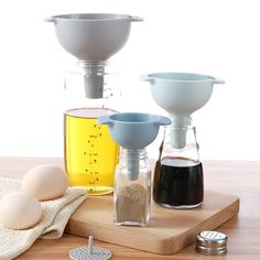 an assortment of cooking ingredients on a cutting board next to measuring cups and spoons