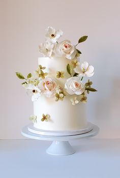 a three tiered white cake with flowers on top