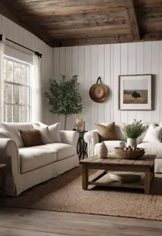 a living room with white couches and wooden floors