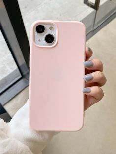 a woman holding up her pink iphone case