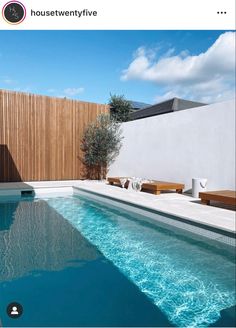 an empty swimming pool in front of a wooden fence