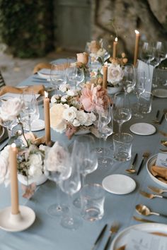 the table is set with flowers and candles