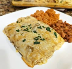 a white plate topped with lasagna and beans