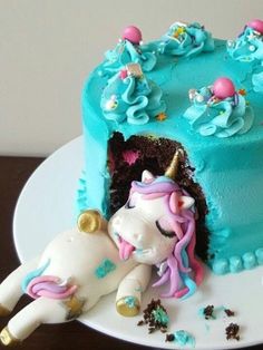 there is a blue cake with a unicorn on it