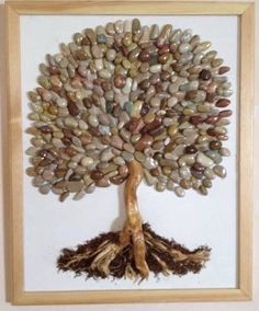 a tree made out of rocks with roots and leaves on the bottom, in a wooden frame