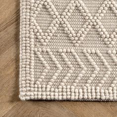 a white rug on top of a wooden floor next to a wood flooring board