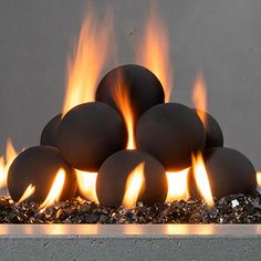 an outdoor fire pit with lots of flames coming out of the top and around it