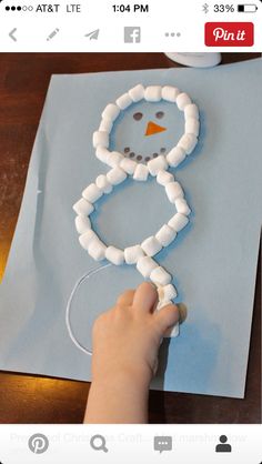 a person making a snowman made out of toilet paper on top of a table