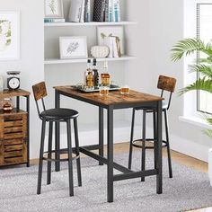 a small table with two stools in front of it and shelves on the wall