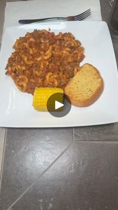 a white plate topped with pasta and corn