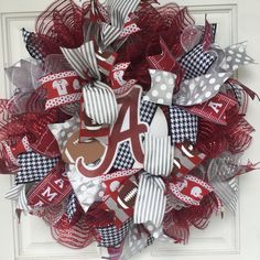 a wreath that has the letter a on it and is decorated with red, white, and gray mesh