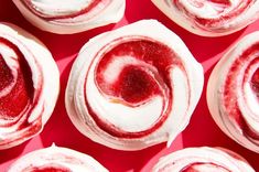 several red and white cupcakes with frosting on top are arranged in a circle