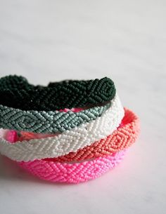 four different colored bracelets sitting on top of each other