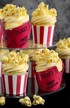 red and white striped cupcakes with yellow frosting on a black table top