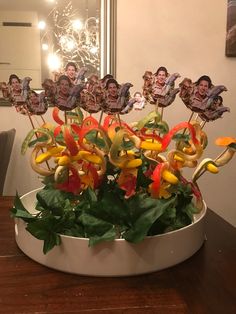 a bowl filled with lots of colorful peppers on top of a wooden table next to a mirror