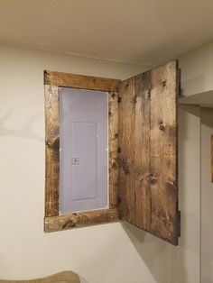 an open window in the side of a wall with a wooden frame and door on it