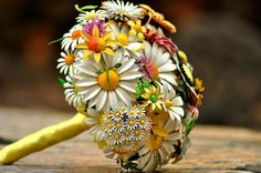 the wedding bouquet is made out of flowers and daisies, which are being held by a