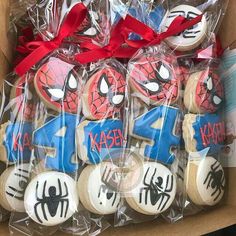 spiderman cookies are wrapped in plastic wrappers and tied with red ribbon on top