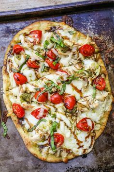 a pizza sitting on top of a pan covered in cheese and veggie toppings