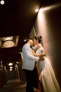 a bride and groom kissing in the hallway