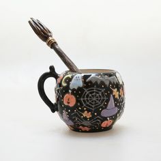 a ceramic cup with a toothbrush in it and halloween decorations on the inside is shown