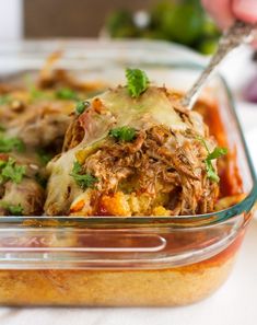 a casserole dish with meat, cheese and parsley on top is ready to be eaten