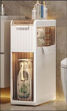 a white refrigerator freezer sitting on top of a bathroom counter next to a toilet