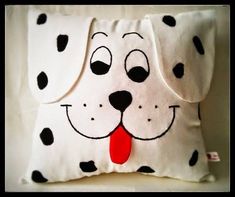 a white and black pillow with a dalmatian face on it's side