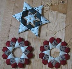 three red, white and blue stars are hanging on a wooden floor next to each other