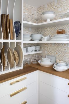 the shelves in this kitchen are filled with plates and bowls