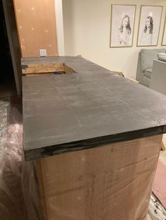 an unfinished kitchen counter top in the process of being installed to a room with pictures on the wall