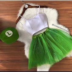 a green tutu skirt and white top on a wooden floor