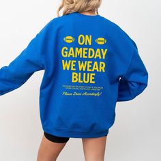 Show your UCLA BRUINS pride with this gameday sweatshirt, perfect for gameday apparel and tailgating outfits. This blue college sports fan gear makes an ideal football fan gift or alumni present, embodying true school spirit for UCLA Bruins supporters. ➡️UCLA BRUINS GAMEDAY FAN SWEATSHIRT:  ✧Features "ON GAMEDAY WE WEAR BLUE"  gold text on front and back. ✧ Sizes range from S -3XL ✧ Heavy Blend cotton and polyester blend crewneck sweatshirt ✧ Relaxed fit, soft feel ✧ No itchy side seams, ribbed Tailgating Outfits, Gameday Sweatshirt, Ucla Bruins Football, Ucla Sweatshirt, College Merch, College Sport, Blue College, California Shirt, Tailgate Outfit