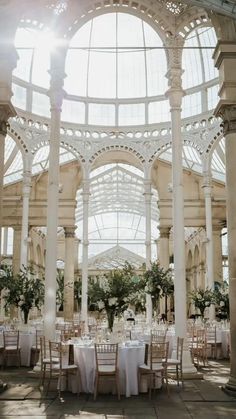 the inside of a building with tables and chairs set up for a formal function in it