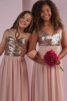 two girls in pink dresses standing next to each other